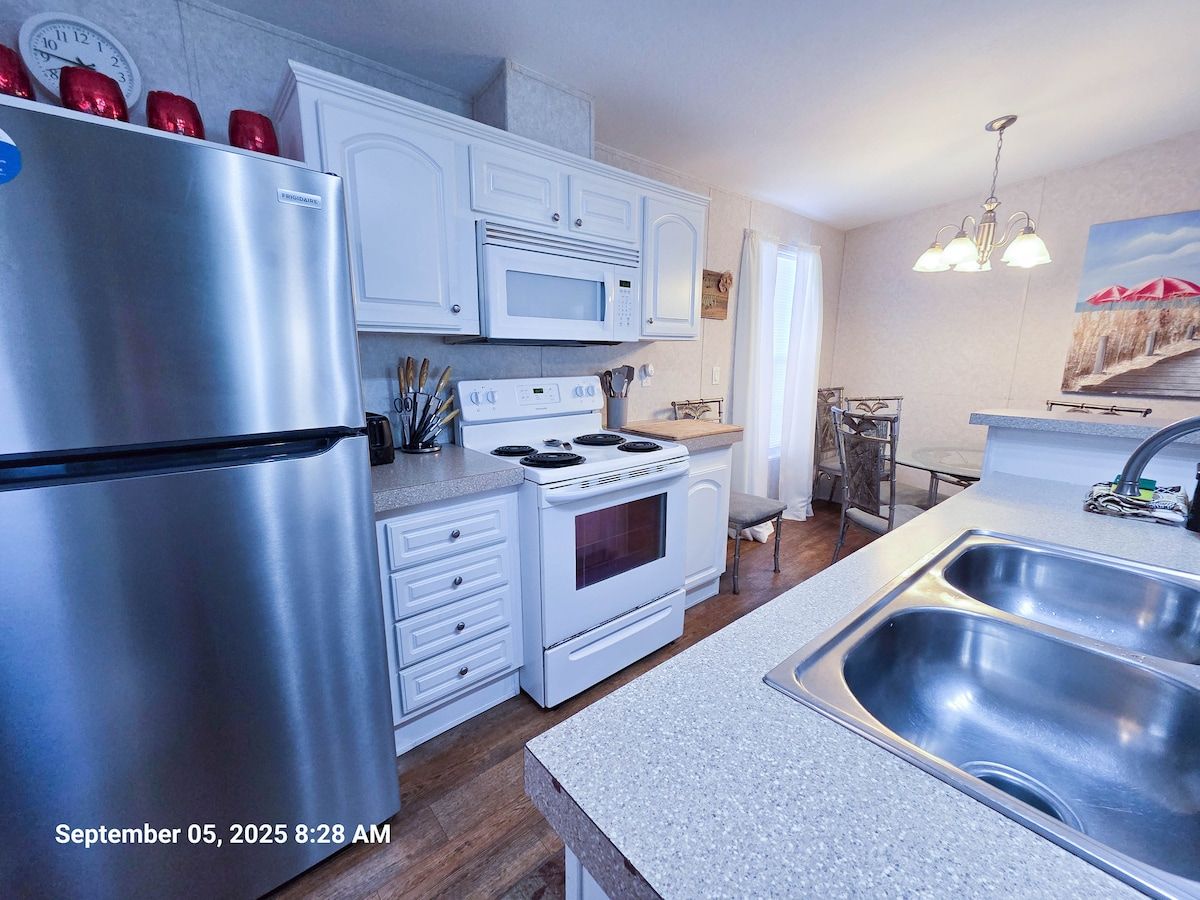 Full Kitchen with microwave, with electric range and cooktop, dishwasher, drip coffee pot, and sink at bar.