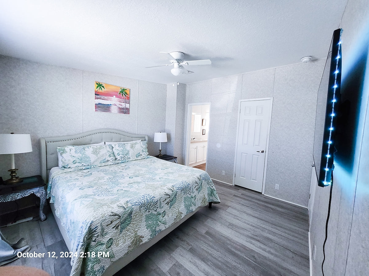 Master Bedroom with King Size Bed, ceiling fan, power strips for electronic devices, and a 55" Samsung Smart TV w/rear led lighting.