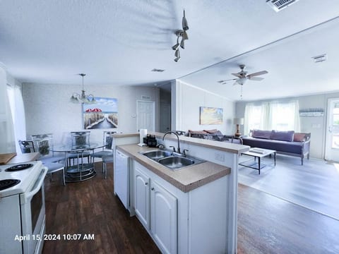 Full Kitchen with microwave, with electric range and cooktop, dishwasher, drip coffee pot, and sink at bar.