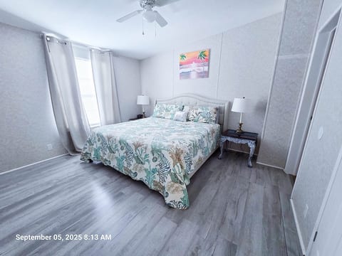 Master Bedroom with King Size Bed, ceiling fan, power strips for electronic devices, and a 55" Samsung Smart TV w/rear led lighting.