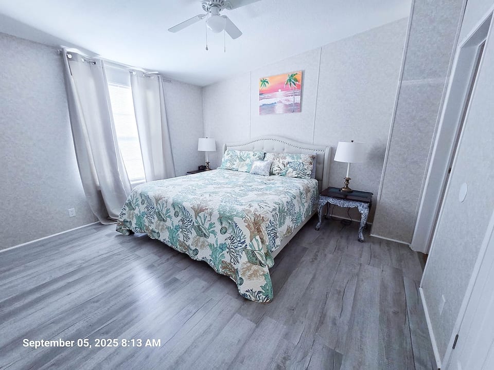 Master Bedroom with King Size Bed, ceiling fan, power strips for electronic devices, and a 55" Samsung Smart TV w/rear led lighting.
