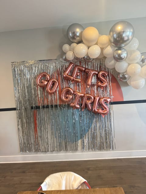 You can create the ultimate Nashville photo op! A dedicated "Let's Go Girls" silver fringe backdrop with balloon garland, ready for your squad’s Insta moments!