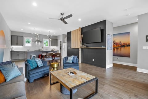 Spacious and modern living area featuring plenty of seating, a large flat-screen TV, and open flow into the kitchen, perfect for gathering the whole group together.