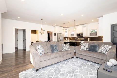 The spacious living room offers plenty of seating on the large sofa and flows seamlessly into the kitchen, ensuring everyone stays connected during your stay.