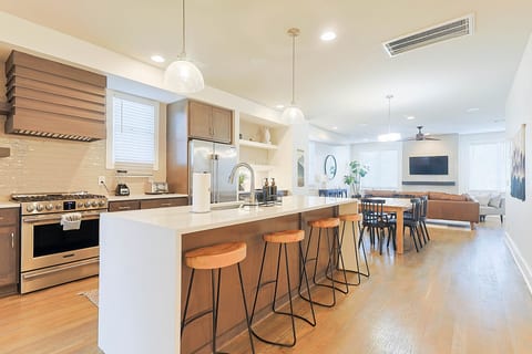 Modern kitchen featuring a large island, bar seating, and high-end stainless appliances.
