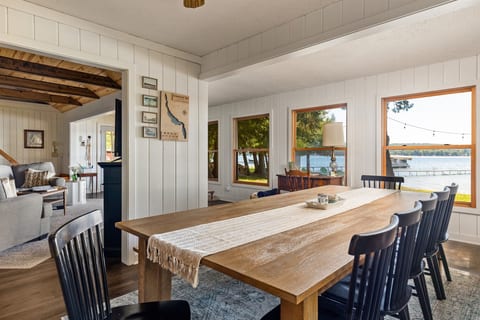 Gather around the large dining table with views of Intermediate Lake just outside the windows. This bright, open space offers the perfect spot for family meals or games, surrounded by the cottage's cozy, rustic charm.