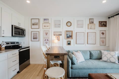Enjoy an open-concept living area with custom gallery walls, comfortable seating, and a charming dining space. Bright, airy, and thoughtfully designed, this room blends coastal elegance with modern comfort.