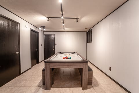 Private game room with pool table and bright modern lighting