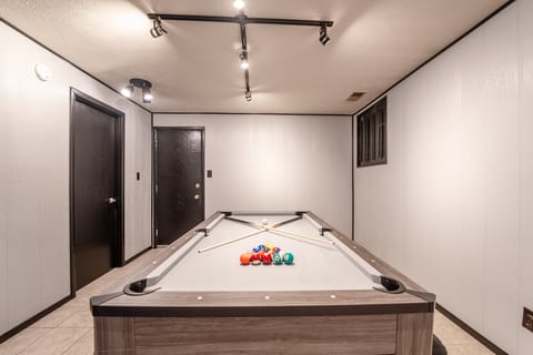 Private game room with full-size pool table and bright modern lighting