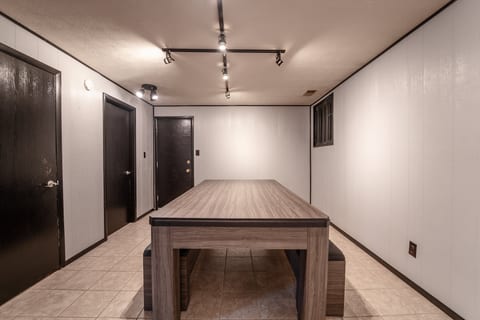 Spacious game room with large table, bench seating, and bright lighting