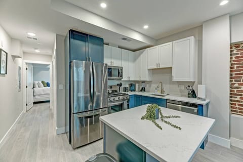 Gourmet Kitchen Awaits: Cook in style with this modern, fully-equipped kitchen featuring stainless steel appliances, sleek cabinetry, and a central island—perfect for preparing meals and entertaining guests!