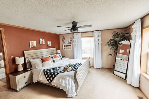 Black out curtains, smart tv, walk in closet, attached full bath, lamps on nightstands, and extra blankets/pillows.