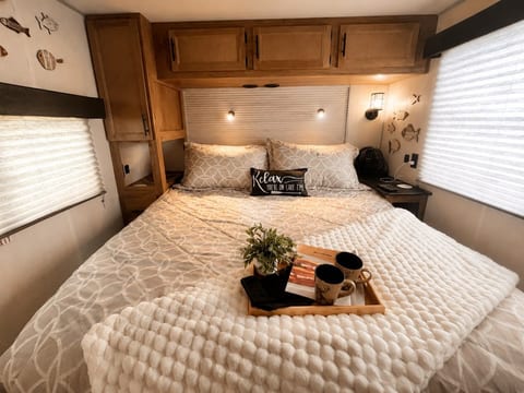 King bed in a private room with cabinets for storage, smart tv, and connected to bathroom.