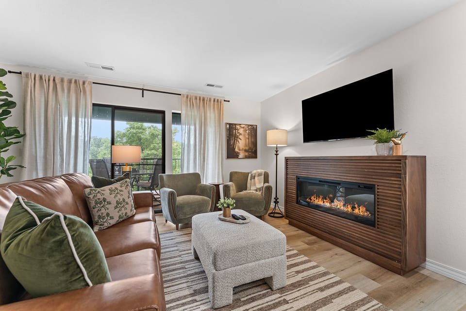 Gather around the electric fireplace in the bright living room. The 65-inch Roku TV includes cable, and the leather sofa opens into a bed for guests 5 and 6.