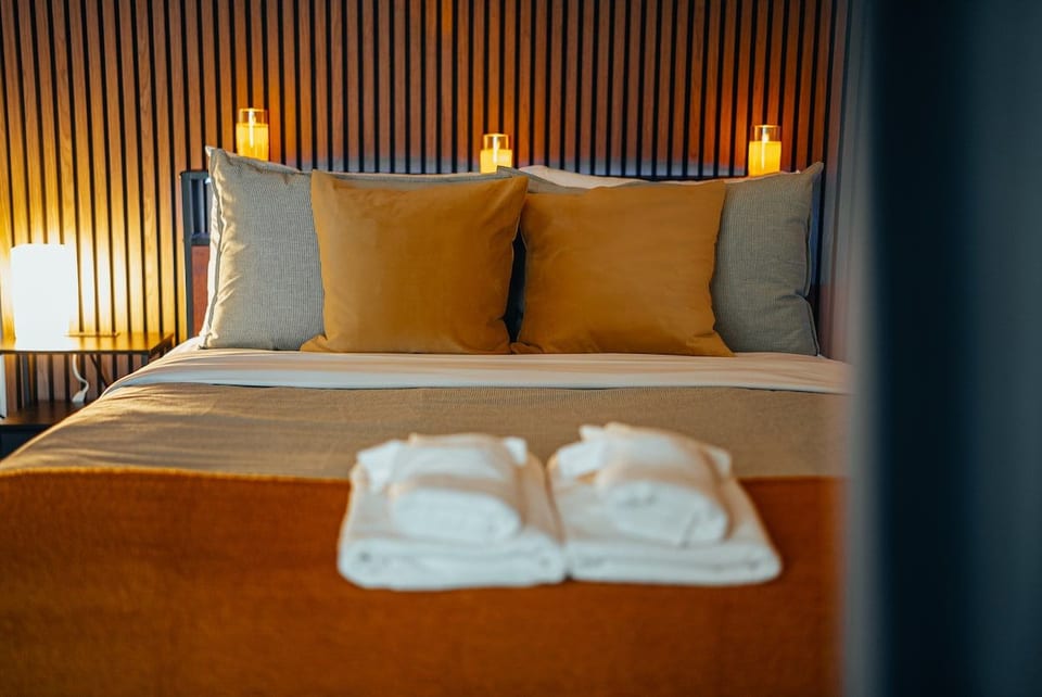 Relax in our stylish bedroom featuring a unique wood accent wall. Enjoy a restful night's sleep in the comfortable queen-sized bed with plush bedding