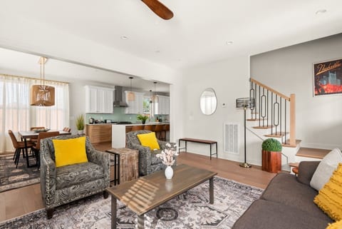Open-concept main level featuring a modern kitchen, spacious island seating, and a sleek staircase.