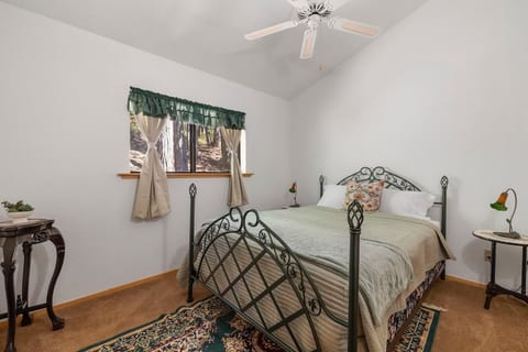 The first bedroom at the top of the staircase to the right is light and airy with vaulted ceilings and calming greens.