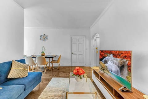 Open-plan living and dining area with smart TV, comfortable seating, and natural light — perfect for relaxing after exploring NYC.