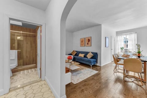 Primary bedroom with plush queen bed, blackout curtains, and serene lighting — quiet sleep in one of Brooklyn's most peaceful neighborhoods.