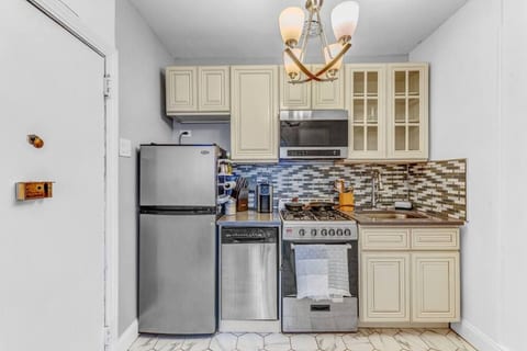 Fully equipped kitchen with stainless steel appliances, full-size fridge, and quality cookware — cook in or order from Brooklyn Heights' top restaurants.