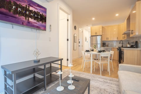 Stylish open-plan unit with kitchen, TV, and cozy dining area