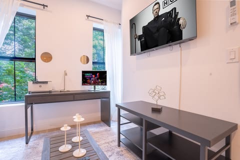 Modern room with desk, TV, and chic décor—perfect for work and streaming