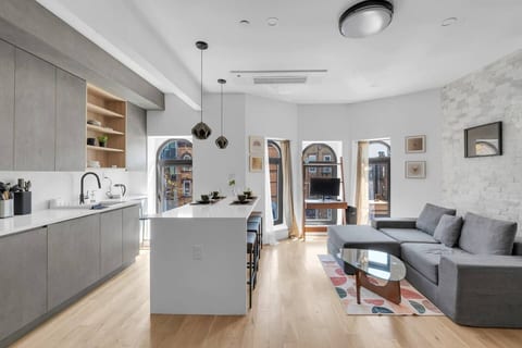 Bright, modern open-concept living and kitchen with a sleek island and arched windows — your stylish Brooklyn retreat.