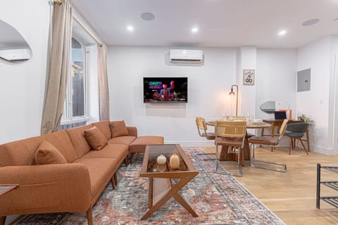 Spacious open-plan living + dining with a cozy sectional, smart TV, and A/C for year-round comfort. Natural light, warm textures, and a table set for four make it perfect for movie nights, meals in, and laid-back hangs