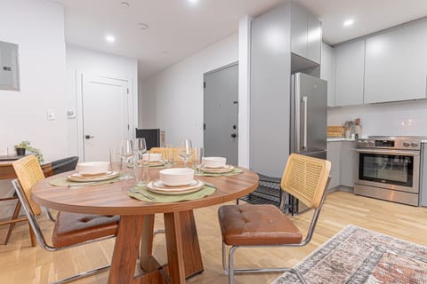 Gather, dine, and unwind—stylish round dining table set for four, right beside a sleek chef’s kitchen with stainless appliances. Perfect for dinner parties, game nights, or a cozy breakfast before heading out