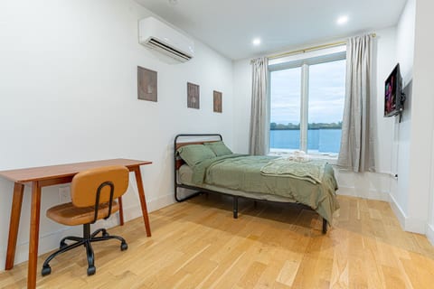 Full bedroom equipped with work desk and bathed in natural sunlight for productivity.