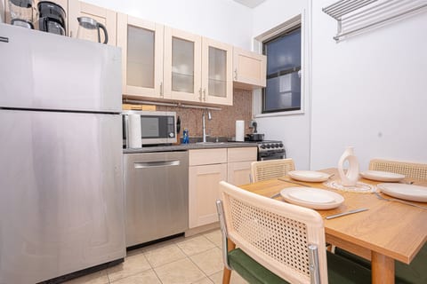 Eat-in kitchen with full-size fridge, stove, and a dining table for home-cooked meals — everything you need for a comfortable UES stay.