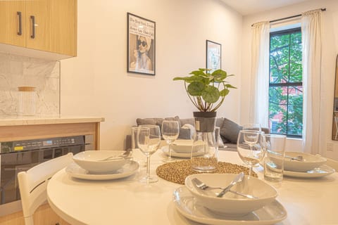 Bright dining area with cozy sofa, modern decor, pendant lighting and garden views.