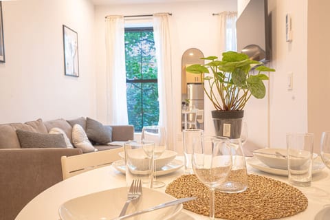 Bright dining space with cozy sofa, large windows, light wood flooring and modern art.