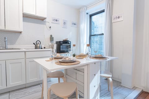 Bright NoMad living room with smart TV, plush seating, and natural light — your stylish 3BR retreat steps from the Empire State Building.