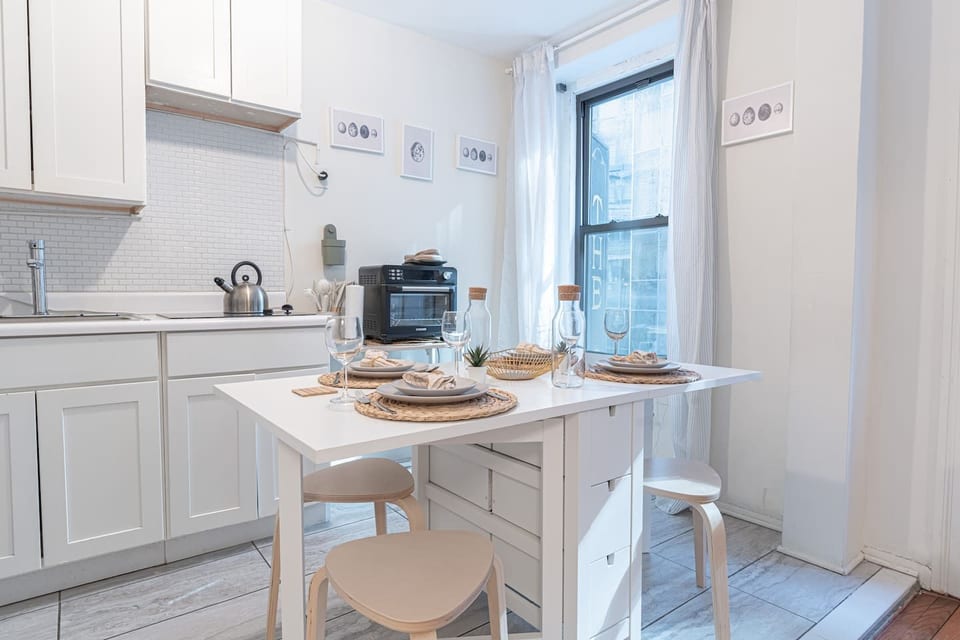 Bright NoMad living room with smart TV, plush seating, and natural light — your stylish 3BR retreat steps from the Empire State Building.