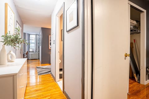 Primary bedroom with plush queen bed, blackout treatments, and smart TV — quiet sleep in midtown Manhattan.