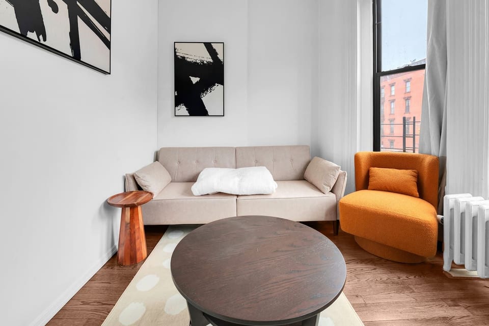 Bright, welcoming living room with plush seating and large windows — your stylish home base in family-friendly Prime Park Slope, Brooklyn.