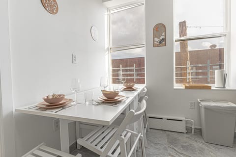 Sunlit kitchen and dining nook with two windows — a cheerful spot for morning coffee and shared meals.