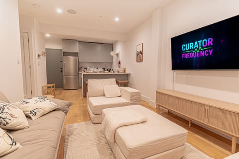 Open-concept living area connects to kitchen, offering a spacious space with Japandi touches.