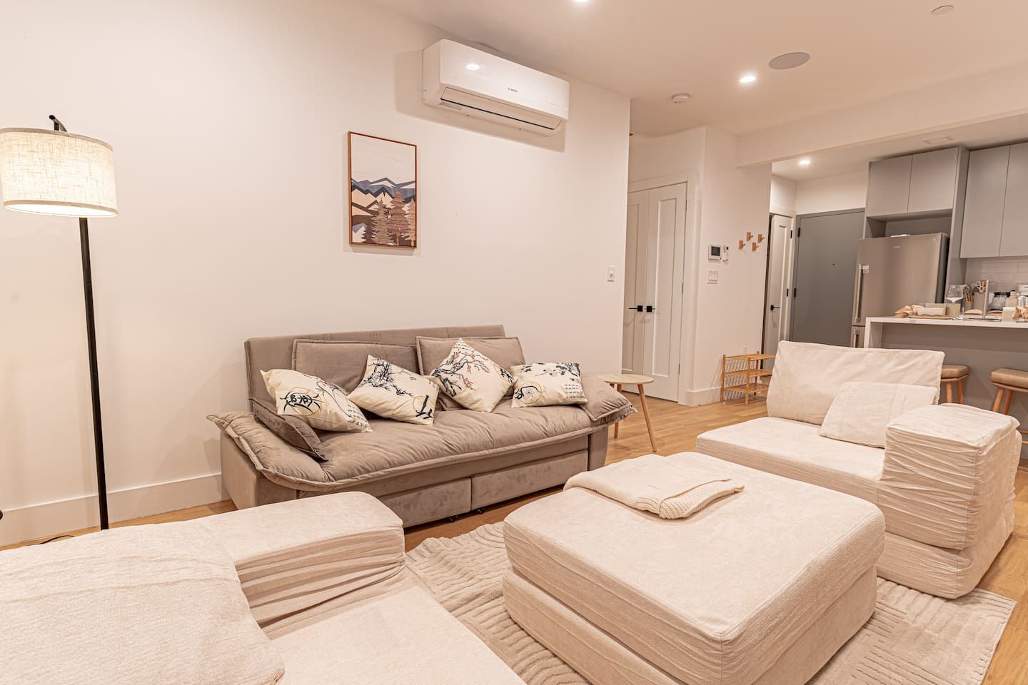 Bright Japandi-style living room with plush sofa and armchairs, perfect for relaxing in Brooklyn.