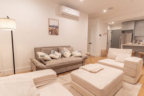 Bright Japandi-style living room with plush sofa and armchairs, perfect for relaxing in Brooklyn.
