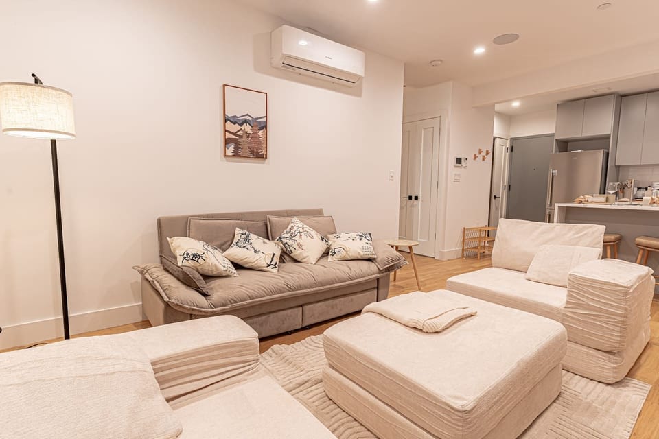 Bright Japandi-style living room with plush sofa and armchairs, perfect for relaxing in Brooklyn.