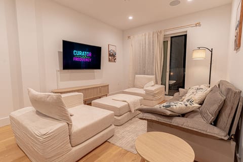 Cozy sitting area with smart TV, neutral décor and soft lighting for streaming and unwinding.