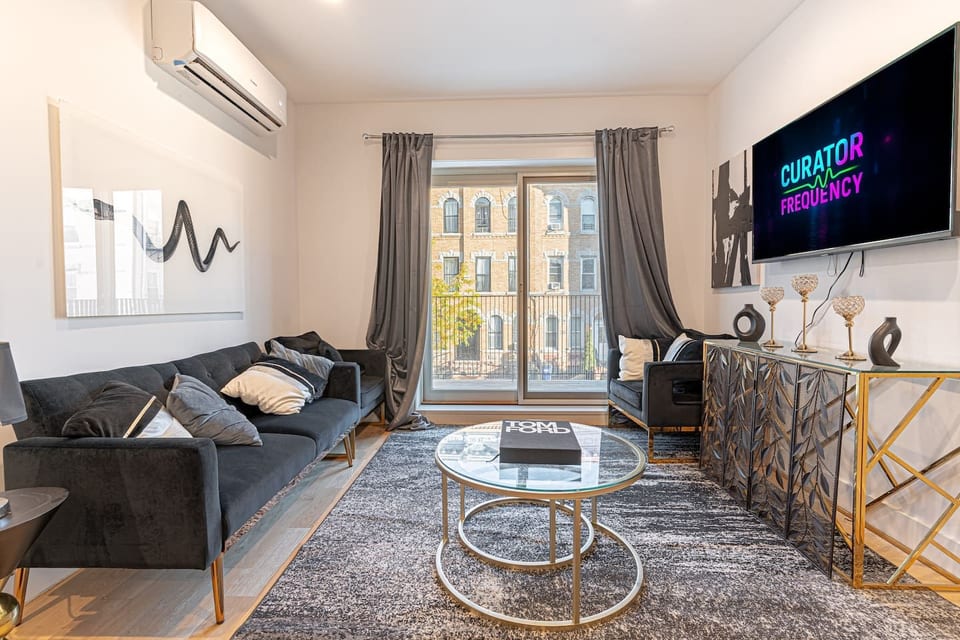 The living room features a Smart TV, a foldable sofa bed, and direct balcony access, creating a comfortable and relaxing space for your stay.