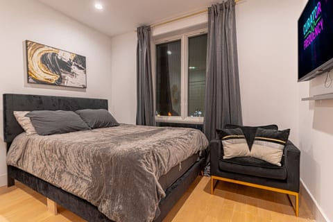 Separate private bedroom with queen bed, soft linens, stylish artwork and natural light