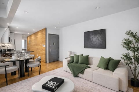 Open-plan dining and kitchen with a round table for four, warm wood accents and an airy layout — gather and dine in this stylish LES loft.