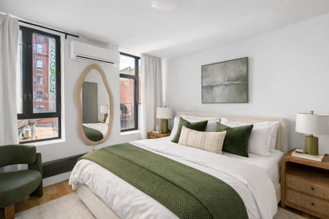 Bright bedroom with city views, cozy bed, and modern decor.