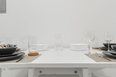 Sunny dining space with glassware and place settings — sit down to coffee or dinner steps from everything.