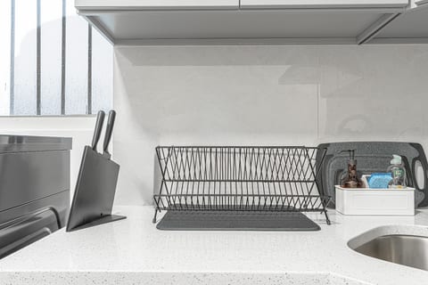 Fully equipped kitchen counter with knife set and dish rack — cook in comfortably between adventures.