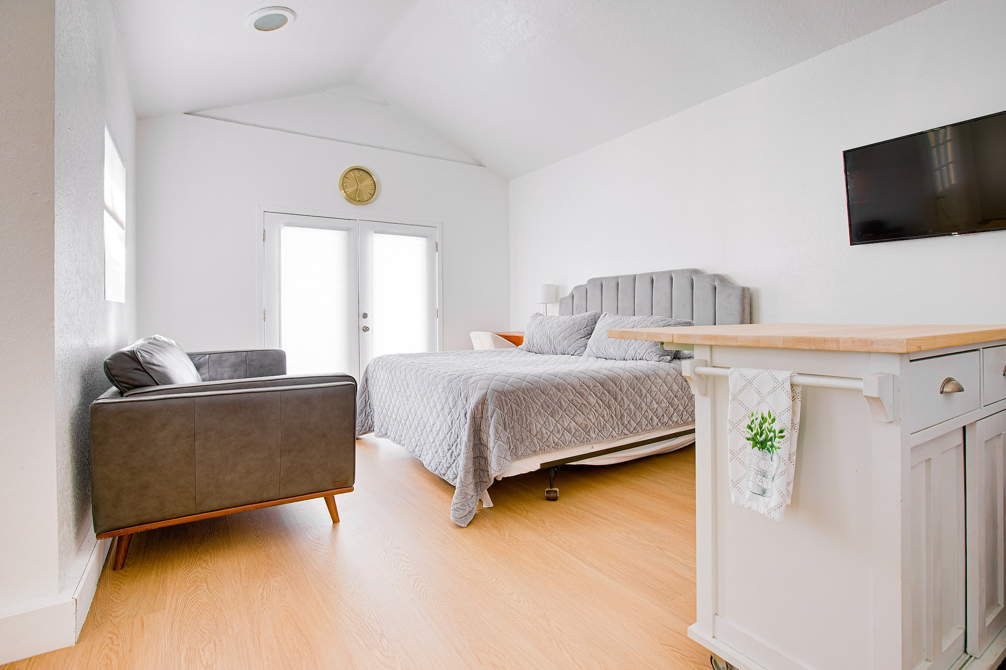 Bright, open studio with a comfortable queen bed, lounge seating, and abundant natural light — your private Granada Hills retreat near CSUN and Universal.